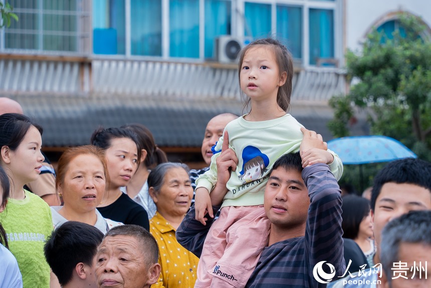現場群眾圍觀少數民族同胞巡游。人民網記者 涂敏攝