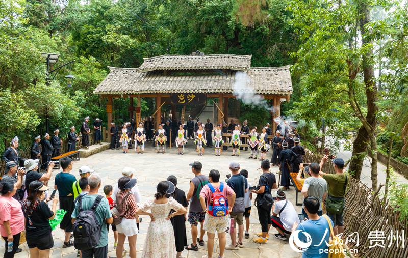 在岜沙苗寨，當(dāng)?shù)孛缱逋谡T迎接游客。 人民網(wǎng) 陽茜攝