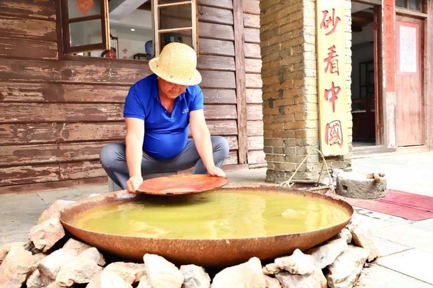 圖為淘洗礦石，提取朱砂。顧蘭云攝