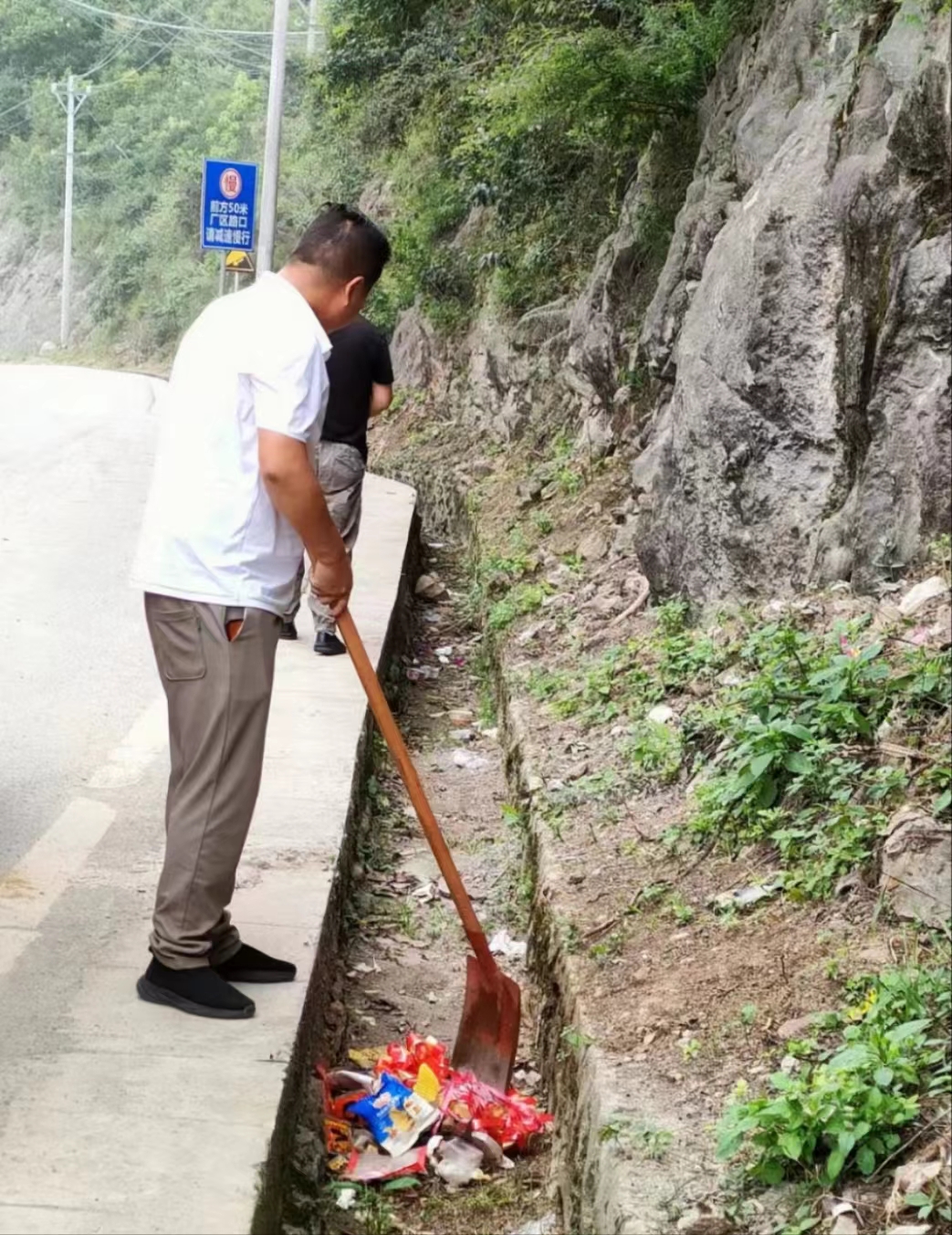 圖為普定縣馬場鎮(zhèn)組織工作人員在公路沿線清理垃圾。