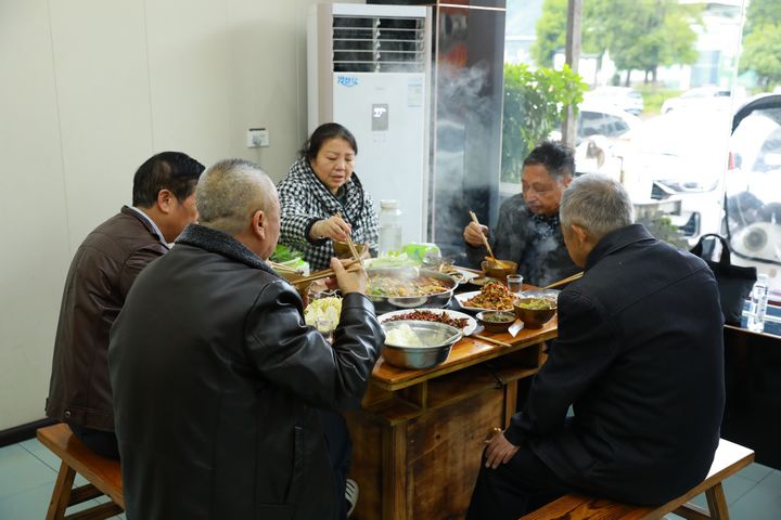 食客們圍坐一桌吃酸湯魚。謝達意攝