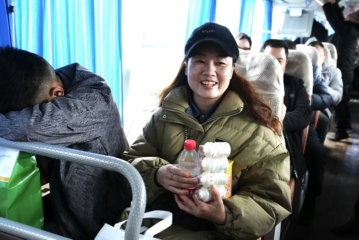 4、外出務(wù)工人員陸久霞拿著工作人員發(fā)放的暖心大禮包。.jpg