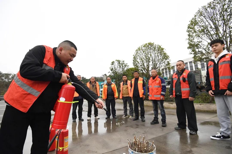環(huán)衛(wèi)工人正在學(xué)習(xí)使用滅火器。
