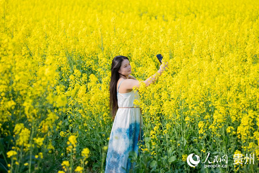 游客在油菜花田中賞花拍照。人民網(wǎng)記者 涂敏攝