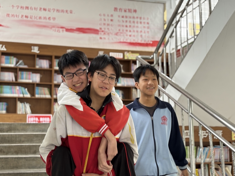 陳璟天背著方證淇走在路上，羅順洋陪在一旁。肖年童攝