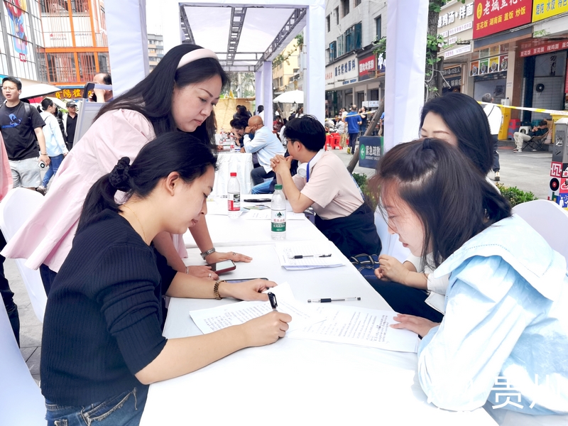 在青云市集的招聘攤位前，求職人員正在填寫信息。人民網(wǎng)記者 王秀芳攝